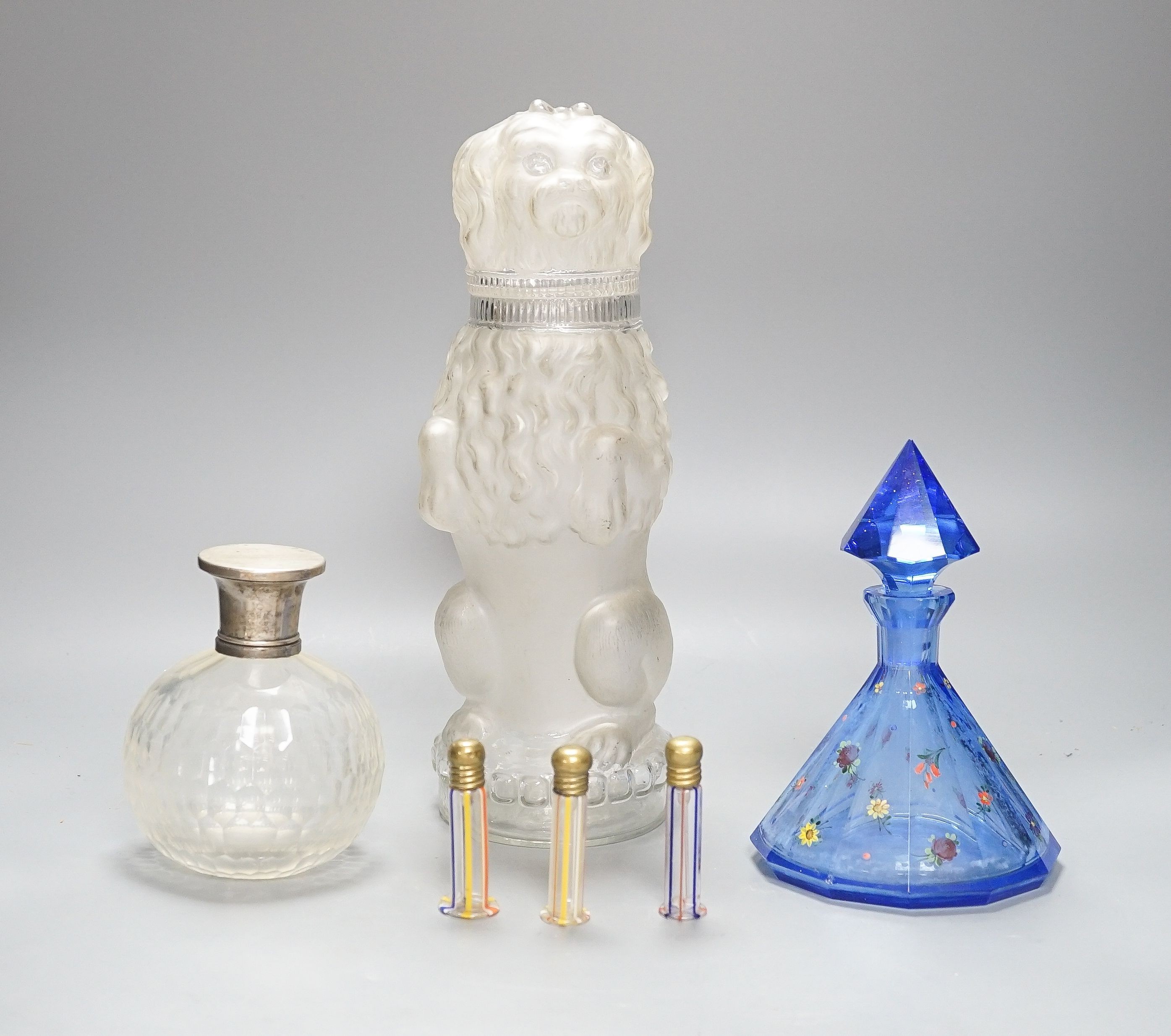 An American novelty dog decanter, silver topped perfume bottle, blue perfume bottle and three candy stripe bottles 32cm